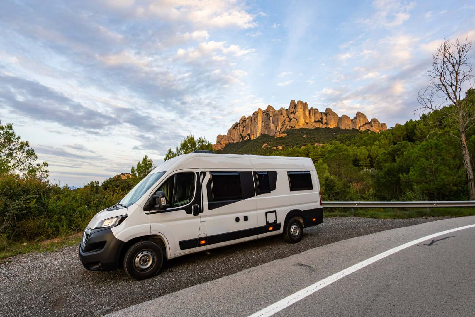 Camper van parked on roadside with Montserrat mountain range in background