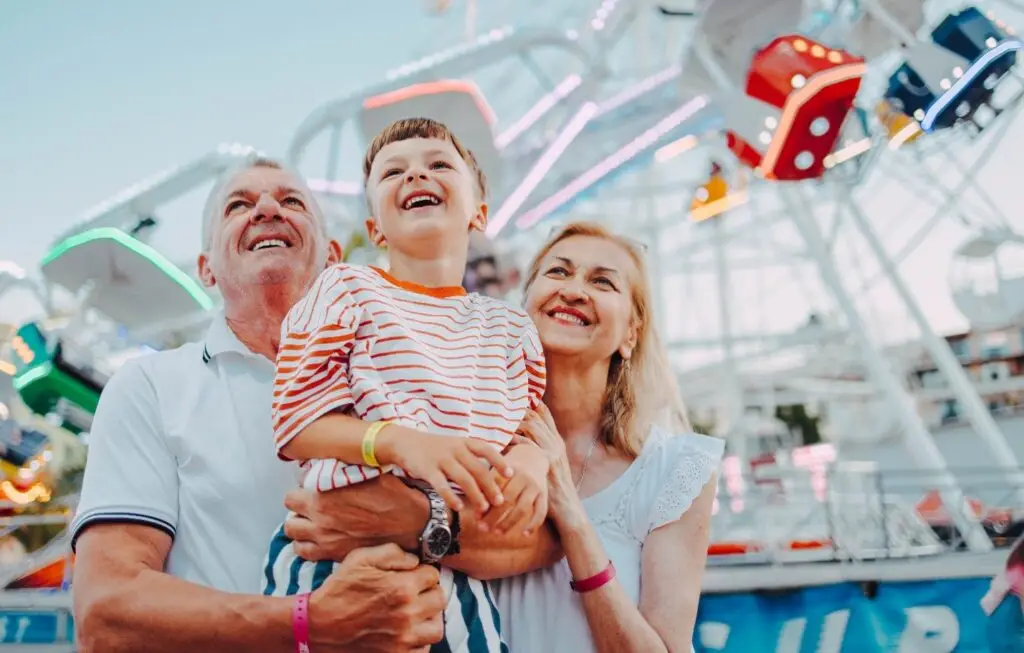 Grandparents and grandson enjoying a day out at a theme park.